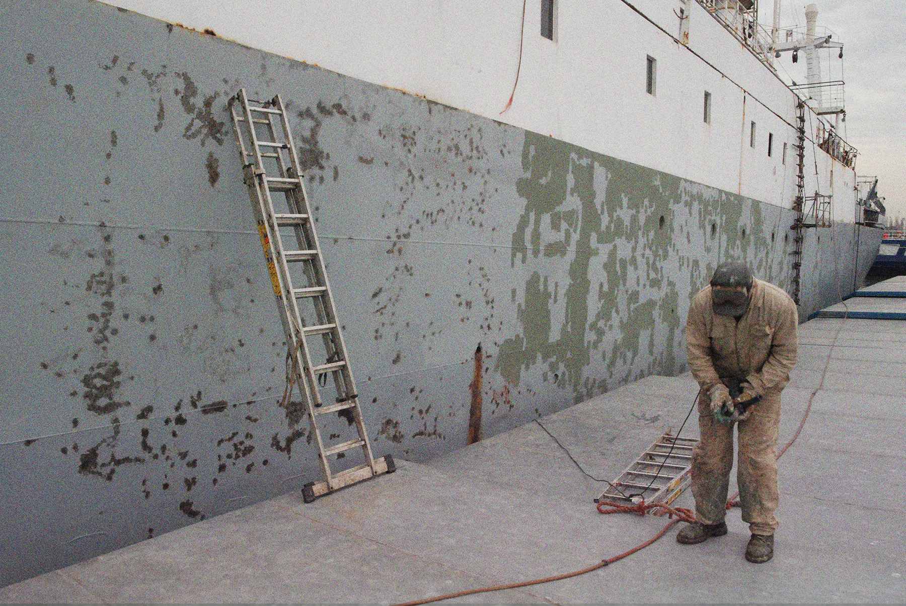 Reperaturarbeiten am Scheergraben 2009. Eine Leiter ist an das Schiff gelehnt. Ein Mann steht daneben und hält einen Winkelschleifer.